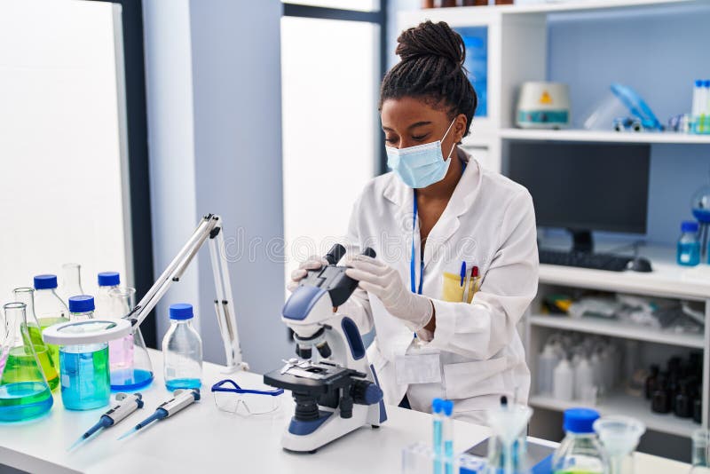 African American Medical Scientist With Microscope In Laboratory