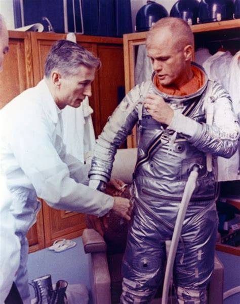 Nasa Technician Joe Schmitt Helps John Glenn Into His Spacesuit During