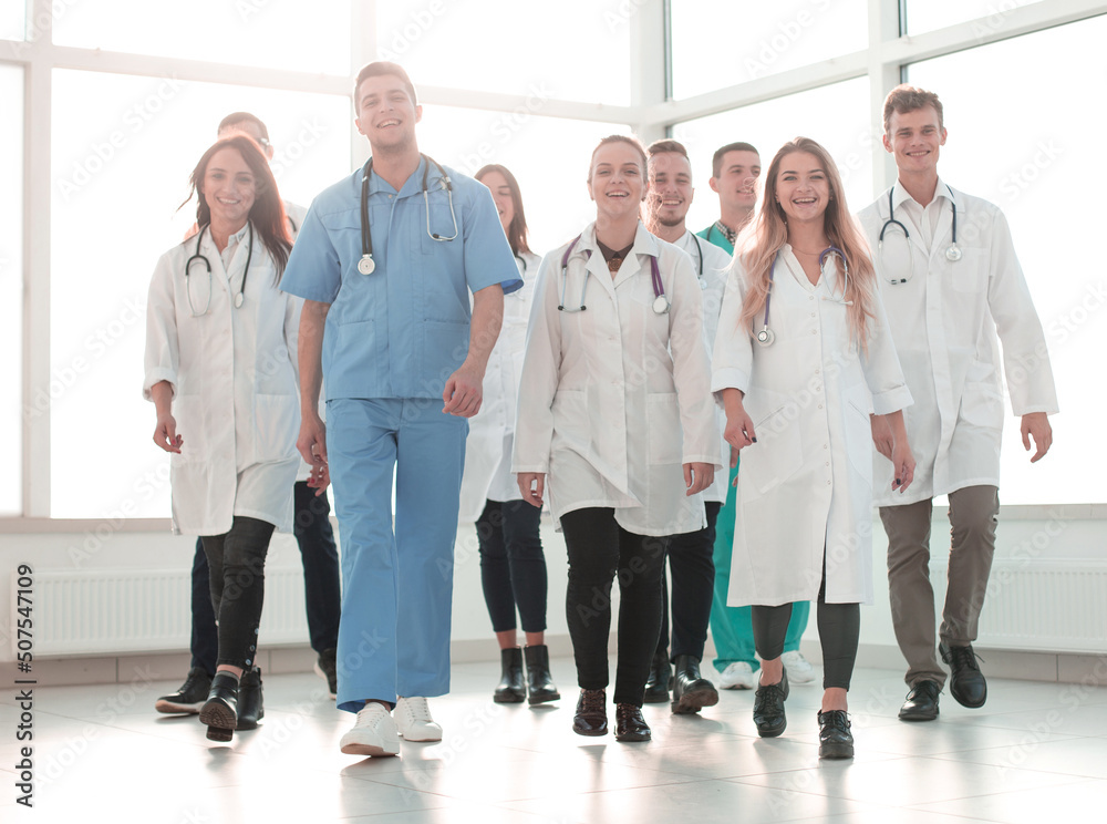 Young Medical Doctors Striding Through The Hospital Corridor Stock